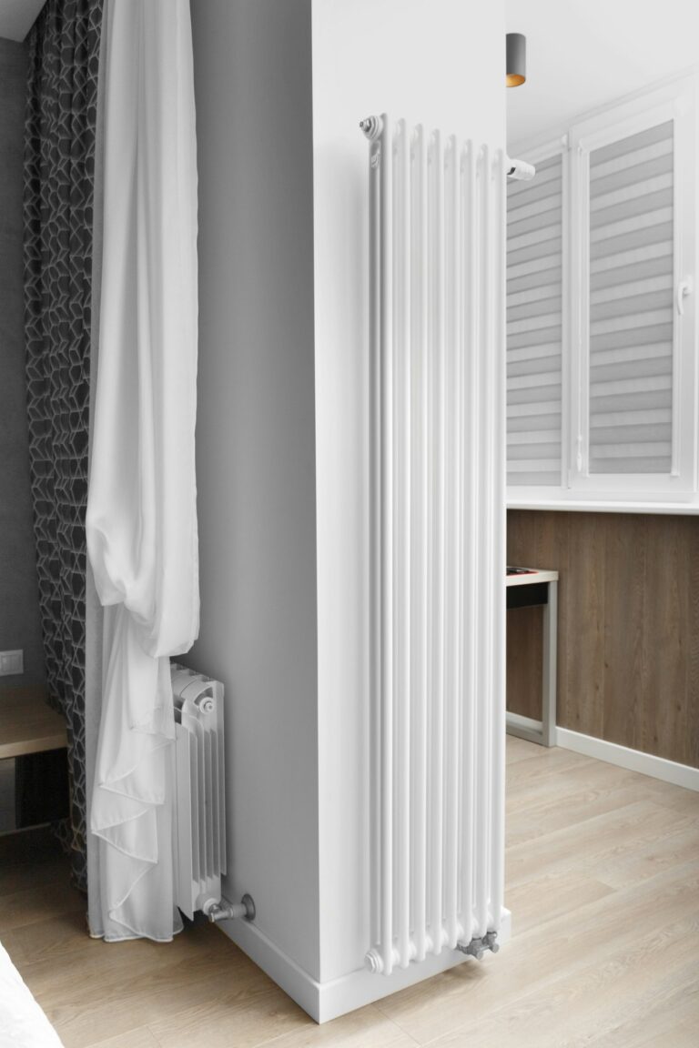 Designer vertical heating radiator on the wall in the interior of an apartment, house.